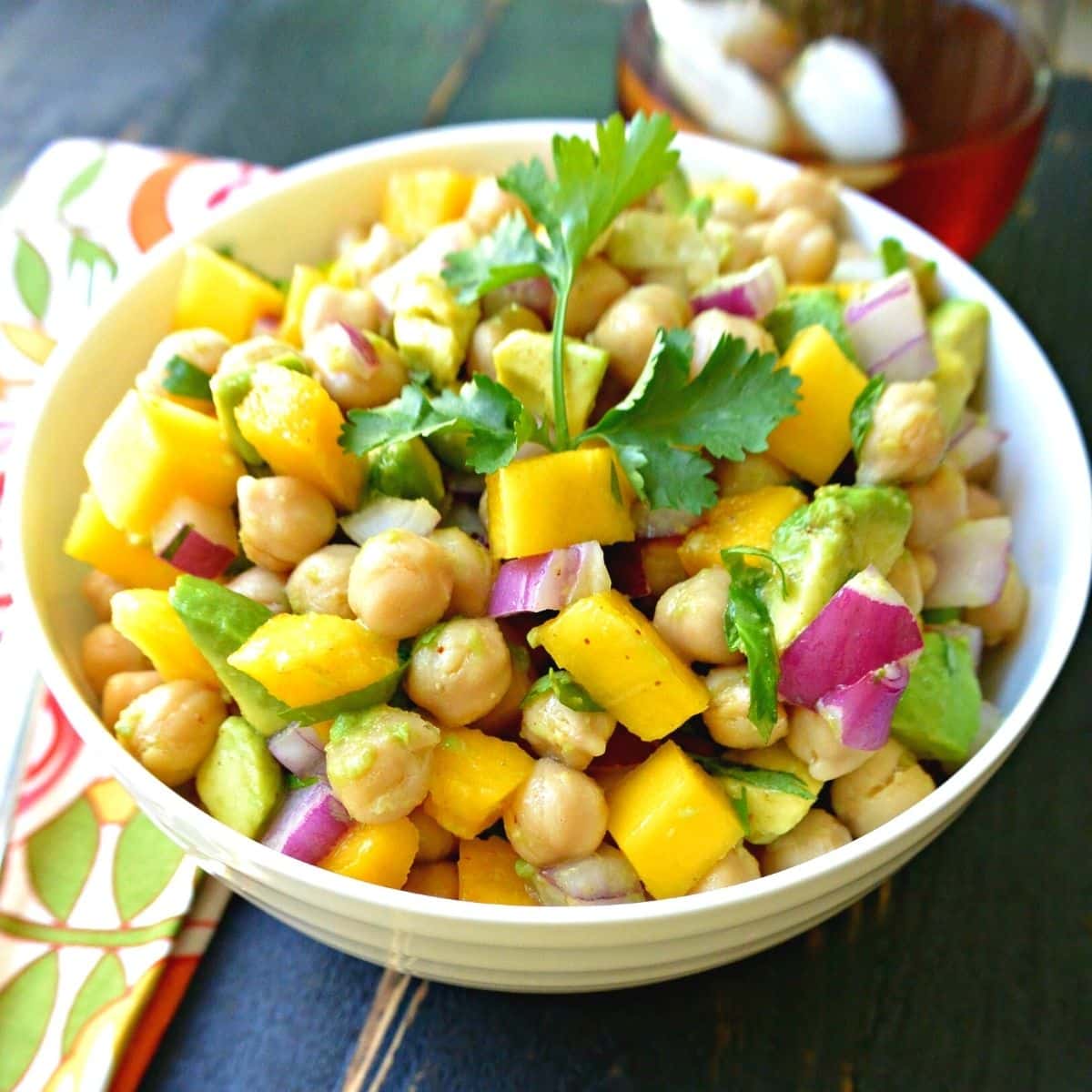 Bowl of salad with a glass of iced tea in the background