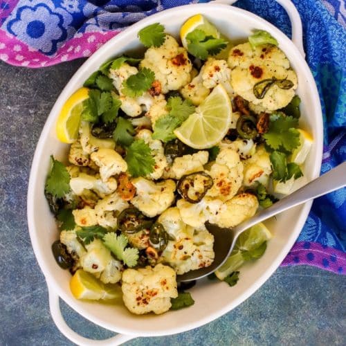 Roasted cauliflower in a serving bowl with a spoon