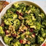Bowl of broccoli salad with text overlay: Vegan Broccoli Cranberry Salad.