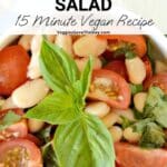 Bowl of salad garnished with a sprig of basil with text overlay: Cherry Tomato and White Bean Salad - 15 Minute Vegan Recipe.