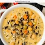 Bowl of creamy soup with text overlay: Vegan Chickpea Wild Rice Soup.