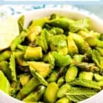 Bowl of asparagus avocado salad with lime and mint.