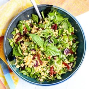 Bowl of spinach salad with a serving spoon in it