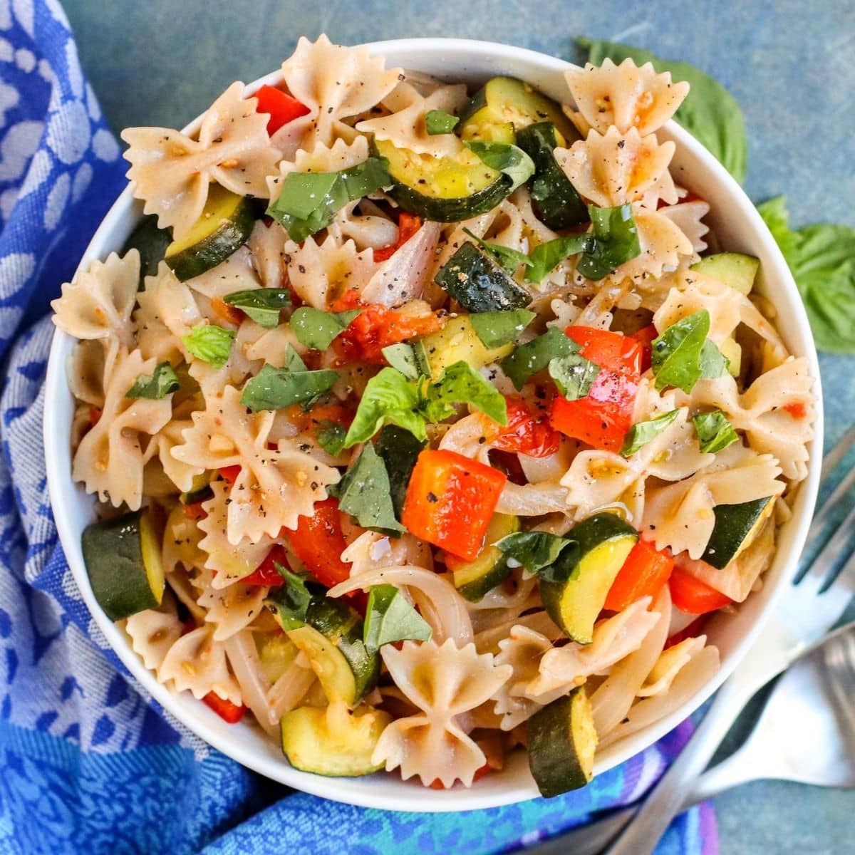 Bowl of farfalle pasta with roasted vegetables and fresh basil
