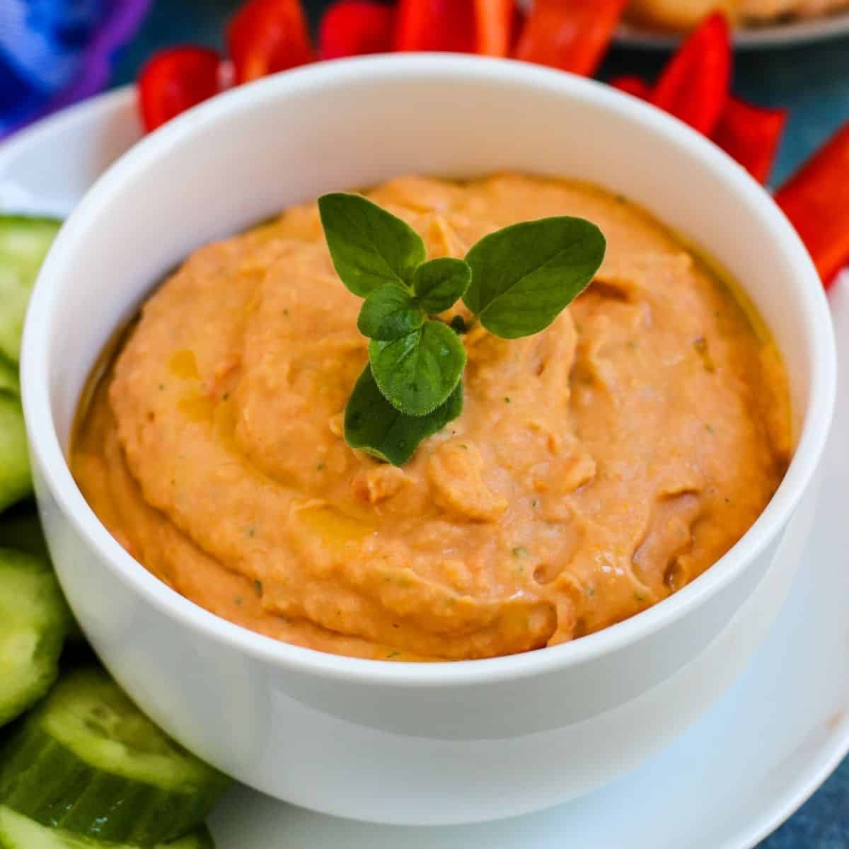 Bowl of dip garnished with a sprig of fresh oregano.