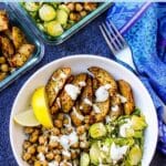 Bowl with roasted chickpeas, potatoes, and Brussels sprouts, drizzled with a creany vegan sauce, with text overlay: Sheet Pan Chickpea and Potato Bowls.