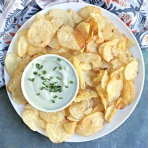 Bowl of Vegan French Onion Dip on a platter of potato chips.