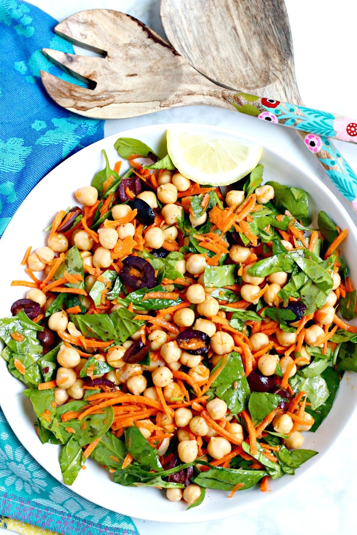 Overhead of bowl of salad and serving utensils