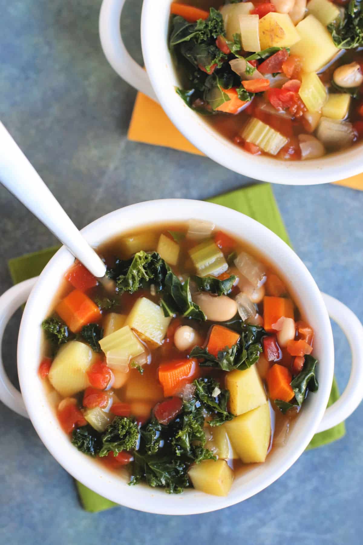 Overhead of two bowls of vegetable  bean and potato soup.