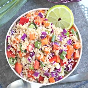 Bowl of Rainbow Quinoa garnished by a slice of lime.