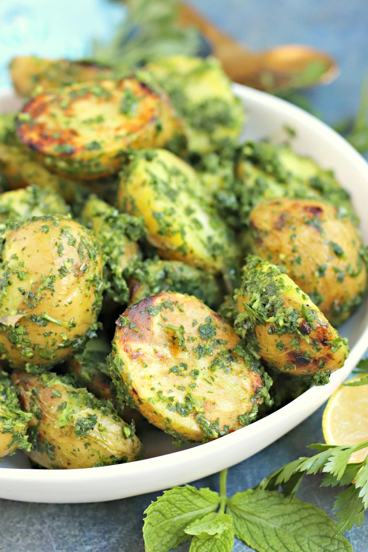 Close up of bowl of potatoes coasted in lemon herb pesto sauce