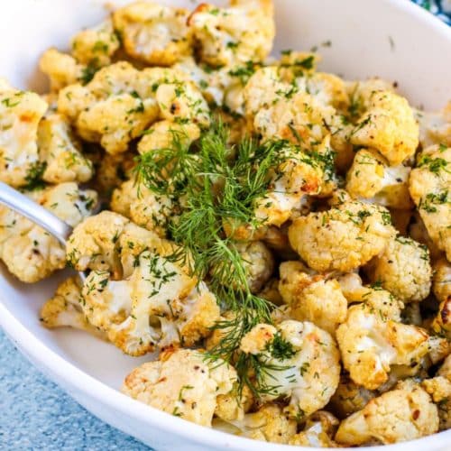 Dish of Mustard Roasted Cauliflower garnished with fresh dill.