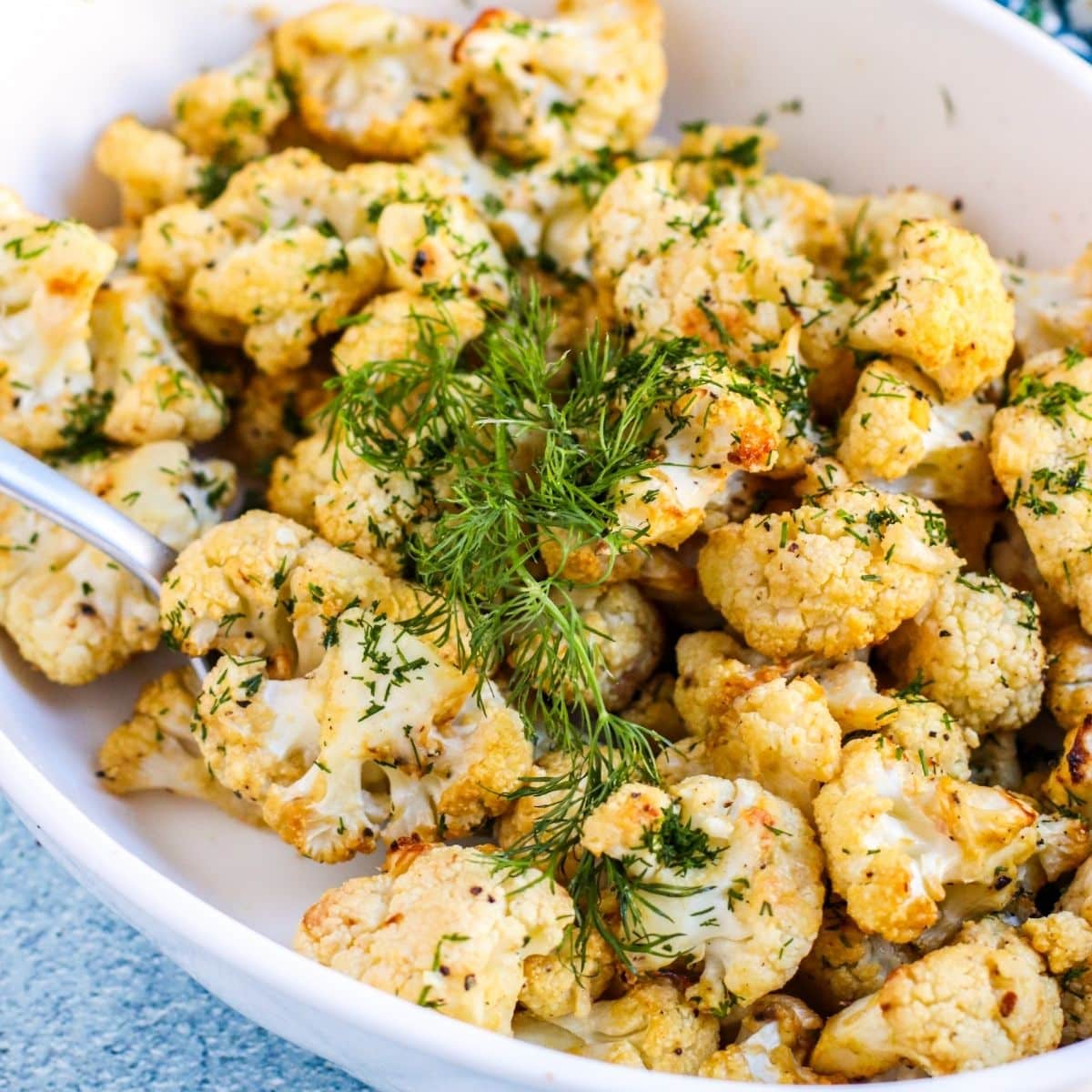 Dish of Mustard Roasted Cauliflower garnished with fresh dill.