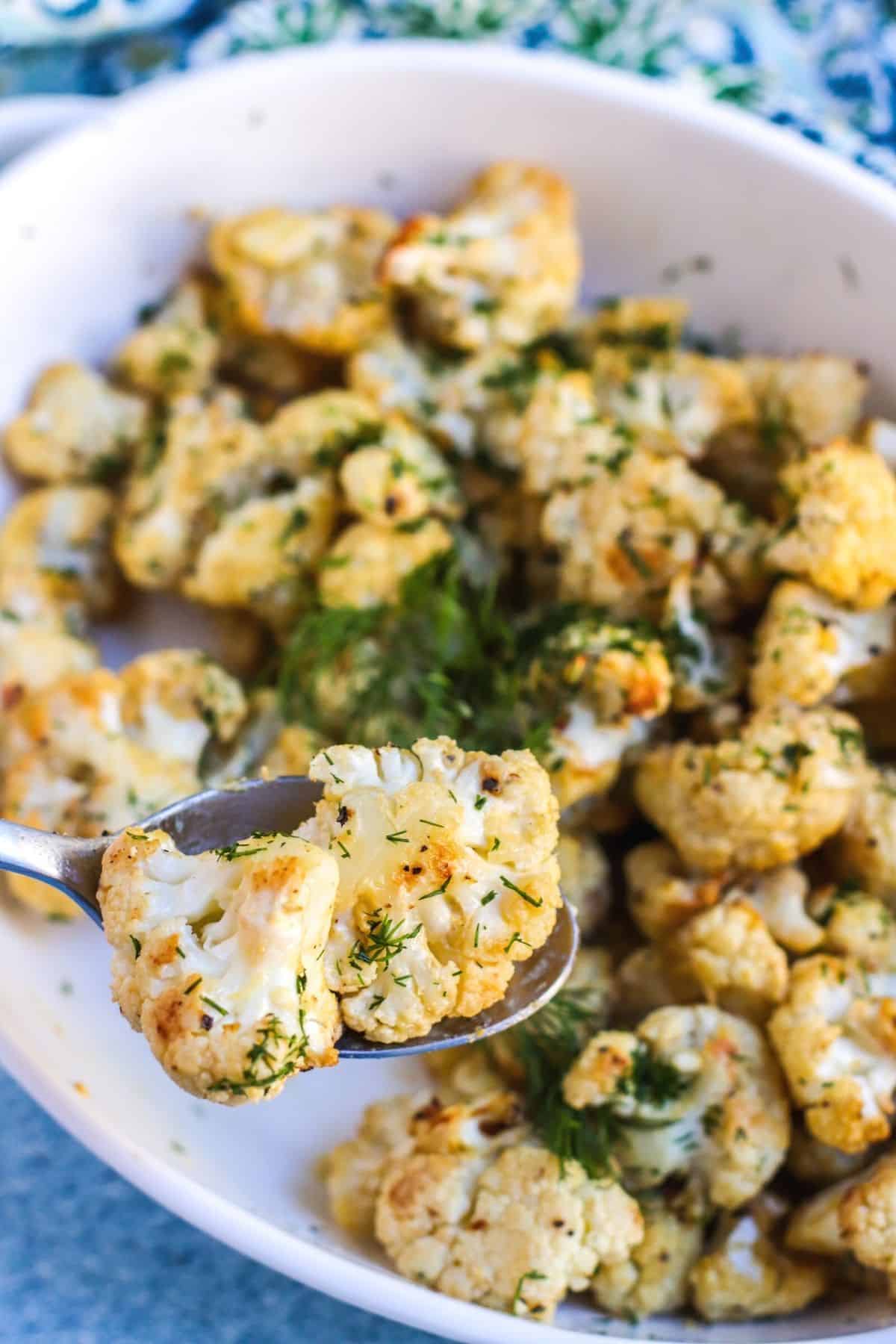 Close up of roasted cauliflower florets on a serving spoon