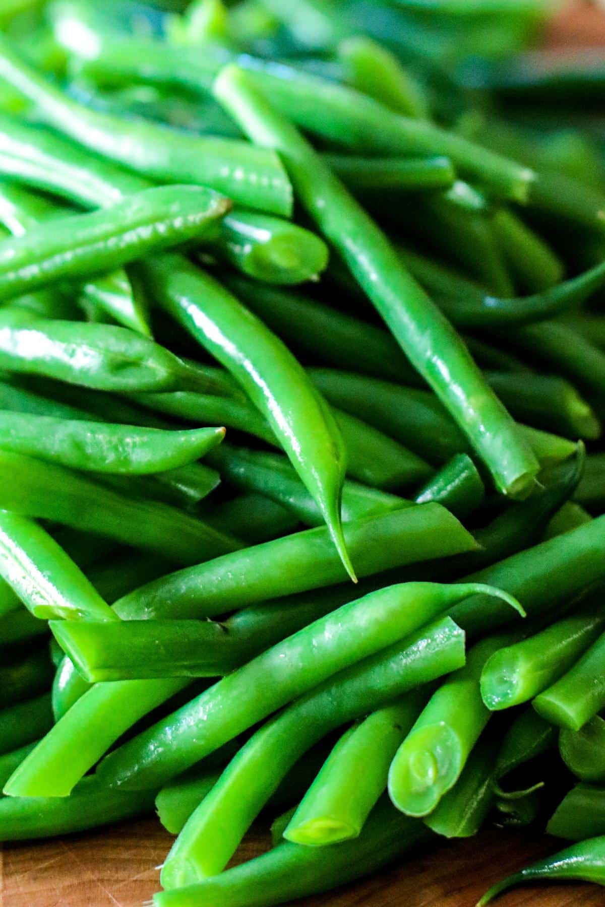 Sliced blanched green beans on a cutting board.