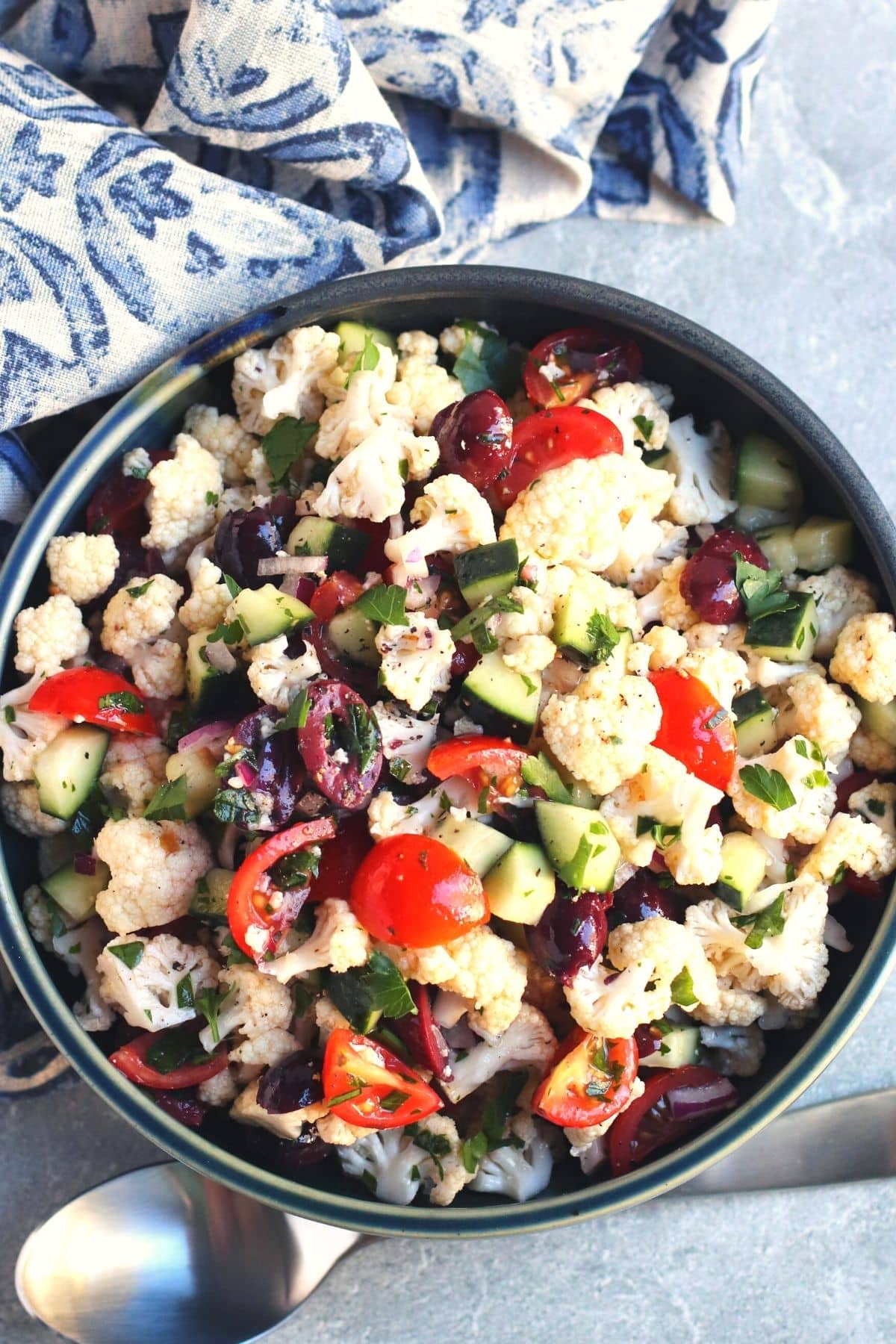 Overhead of a bowl of Cauliflower Salad and blue napkin