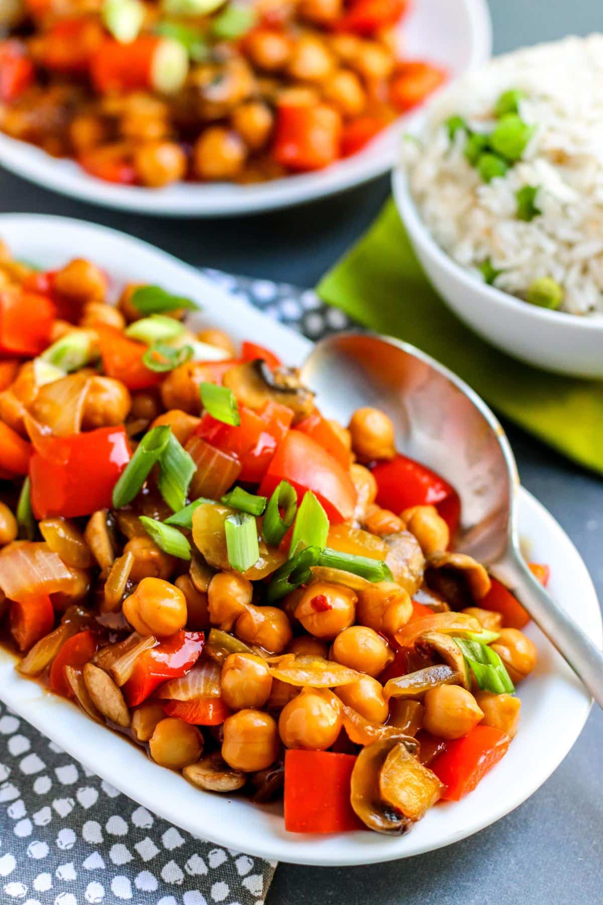 Platter of chickpea stir fry with a serving spoon in it.