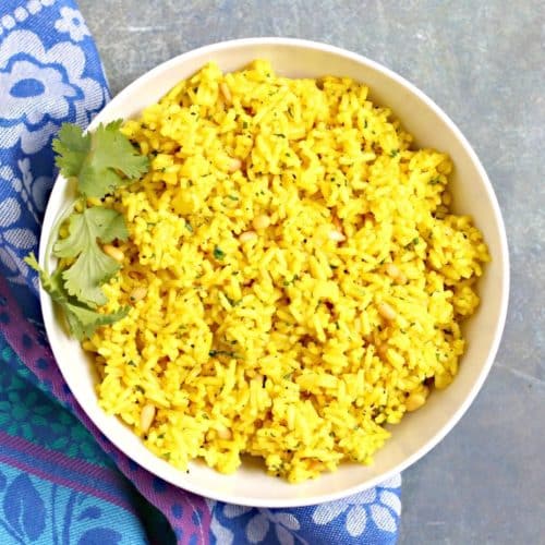 Bowl of turmeric rice garnished with fresh cilantro