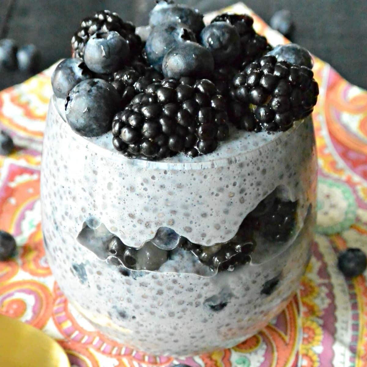 Blueberry and blackberry chia pudding in a glass topped with fresh berries