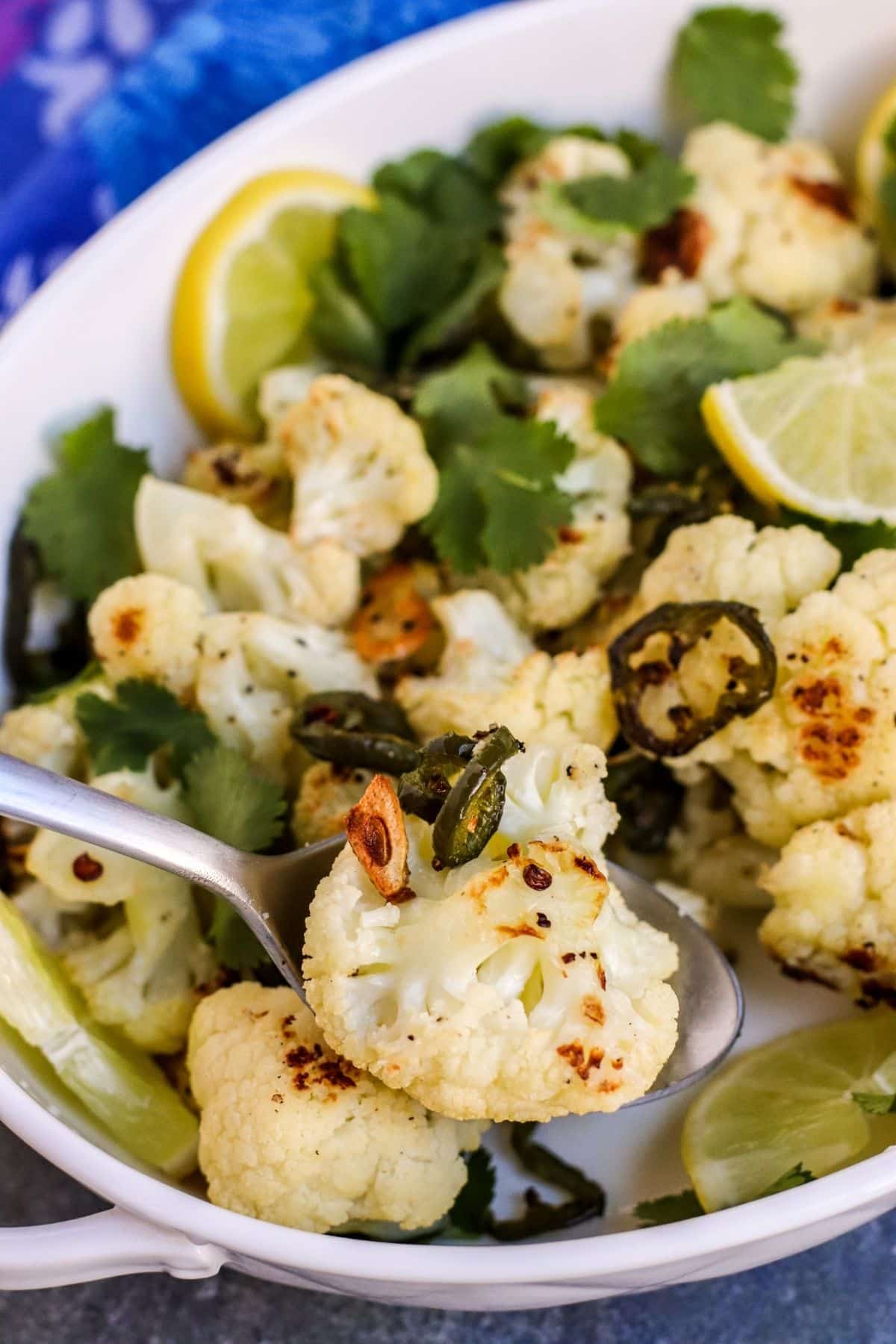 Close up of roasted cauliflower, garlic, and jalapeño slice on a serving spoon