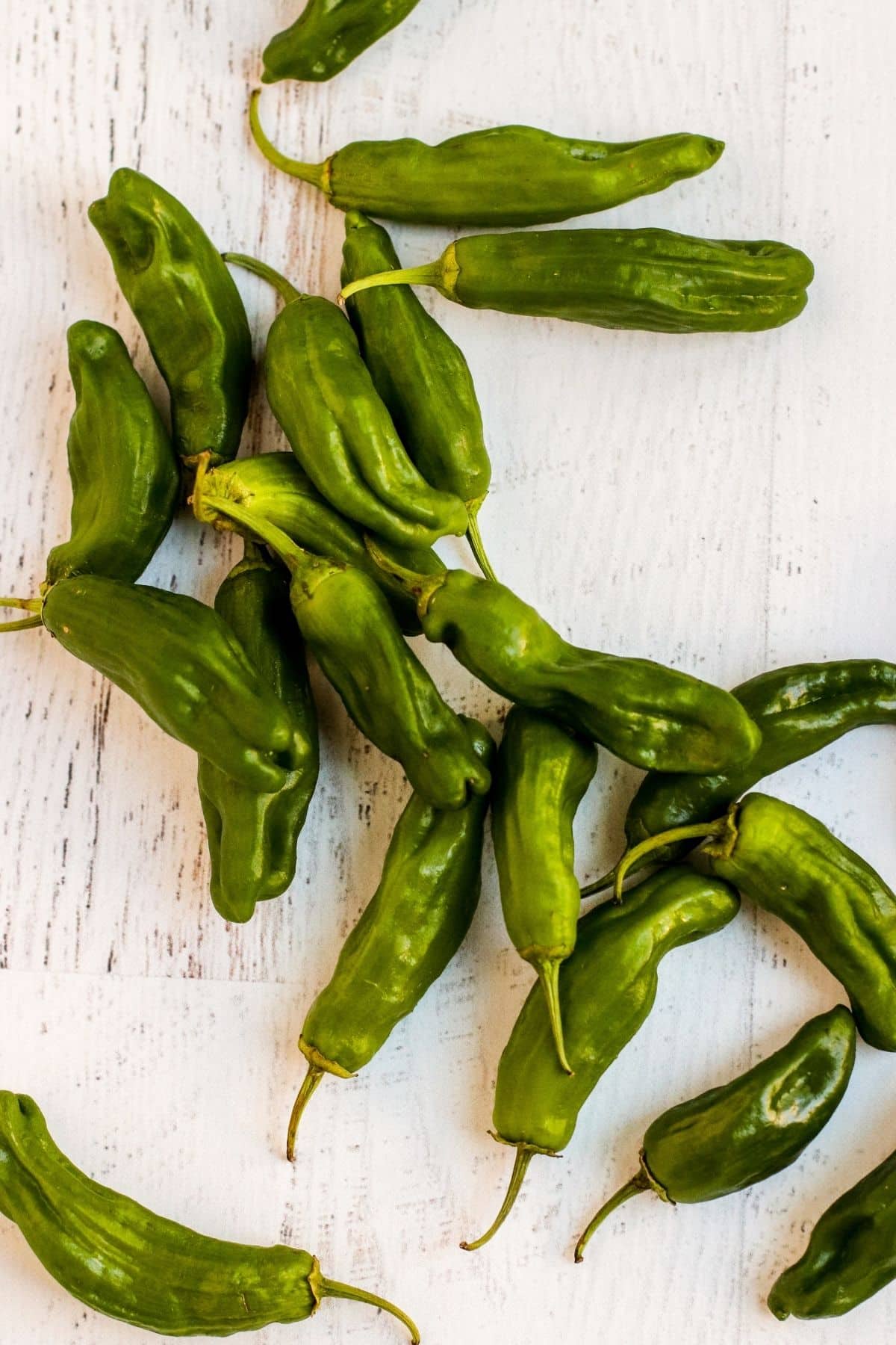 Raw Shishito peppers on a board