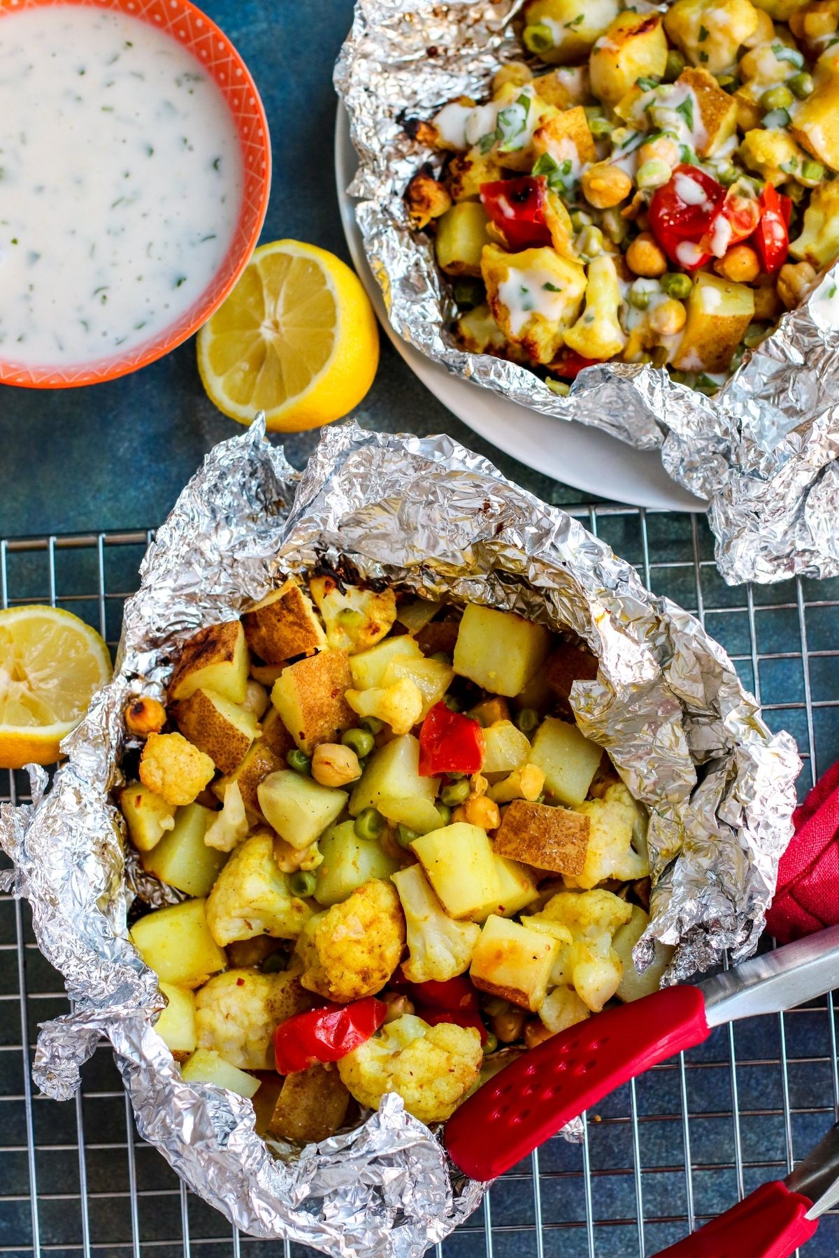 Finished grill packets opened and served with yogurt sauce and lemons