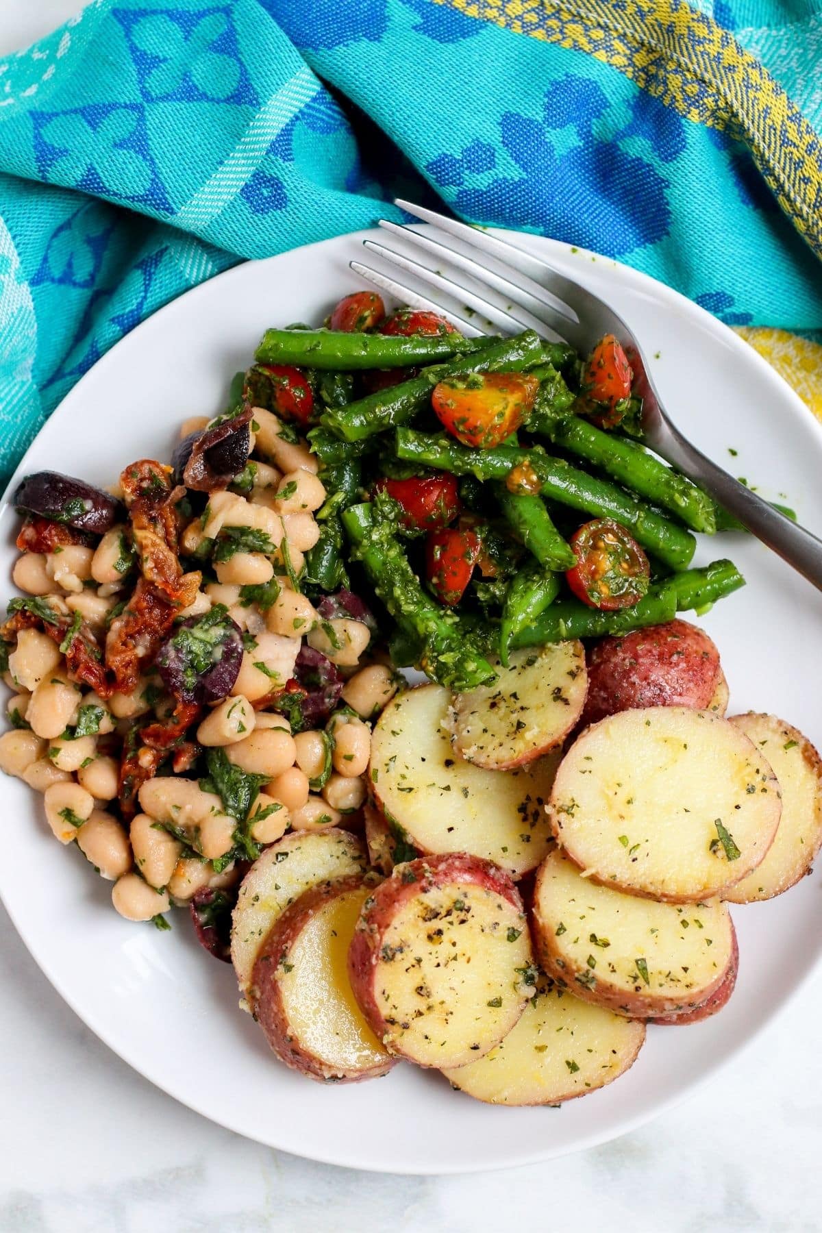 Plate with Mediterranean Green Bean Salad, Greek Vegan Potato Salad, and Mediterranean Cannellini Bean Salad