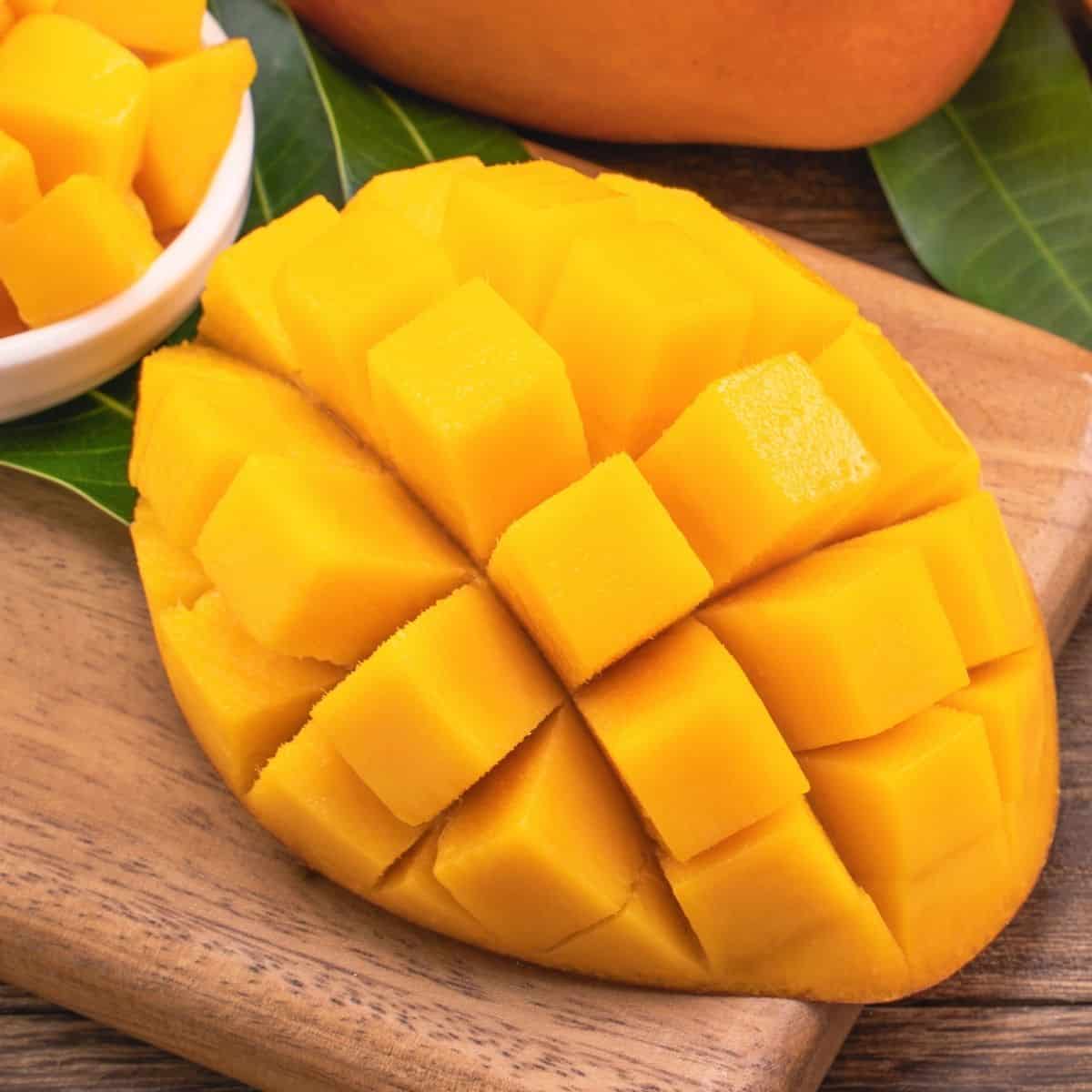 Mango on a cutting board sliced into a grid pattern to form cubes