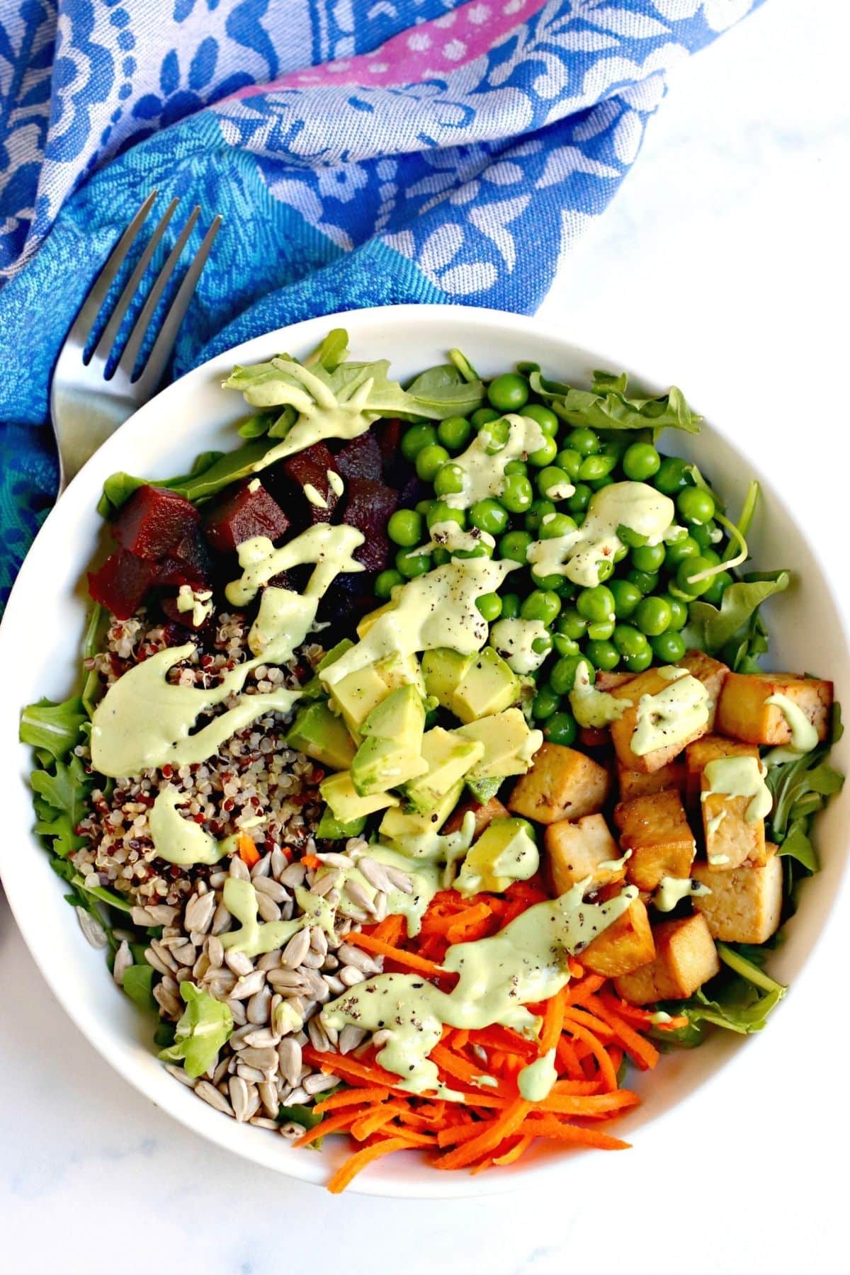 Dressing drizzled over a bowl of vegan Cobb Salad