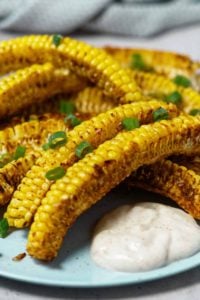 Corn ribs on a plate with a dollop of sauce