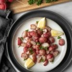 Roasted radishes and lemon wedges on a plate