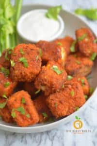 Buffalo tofu nuggets in a bowl with celery sticks and Ranch dressing