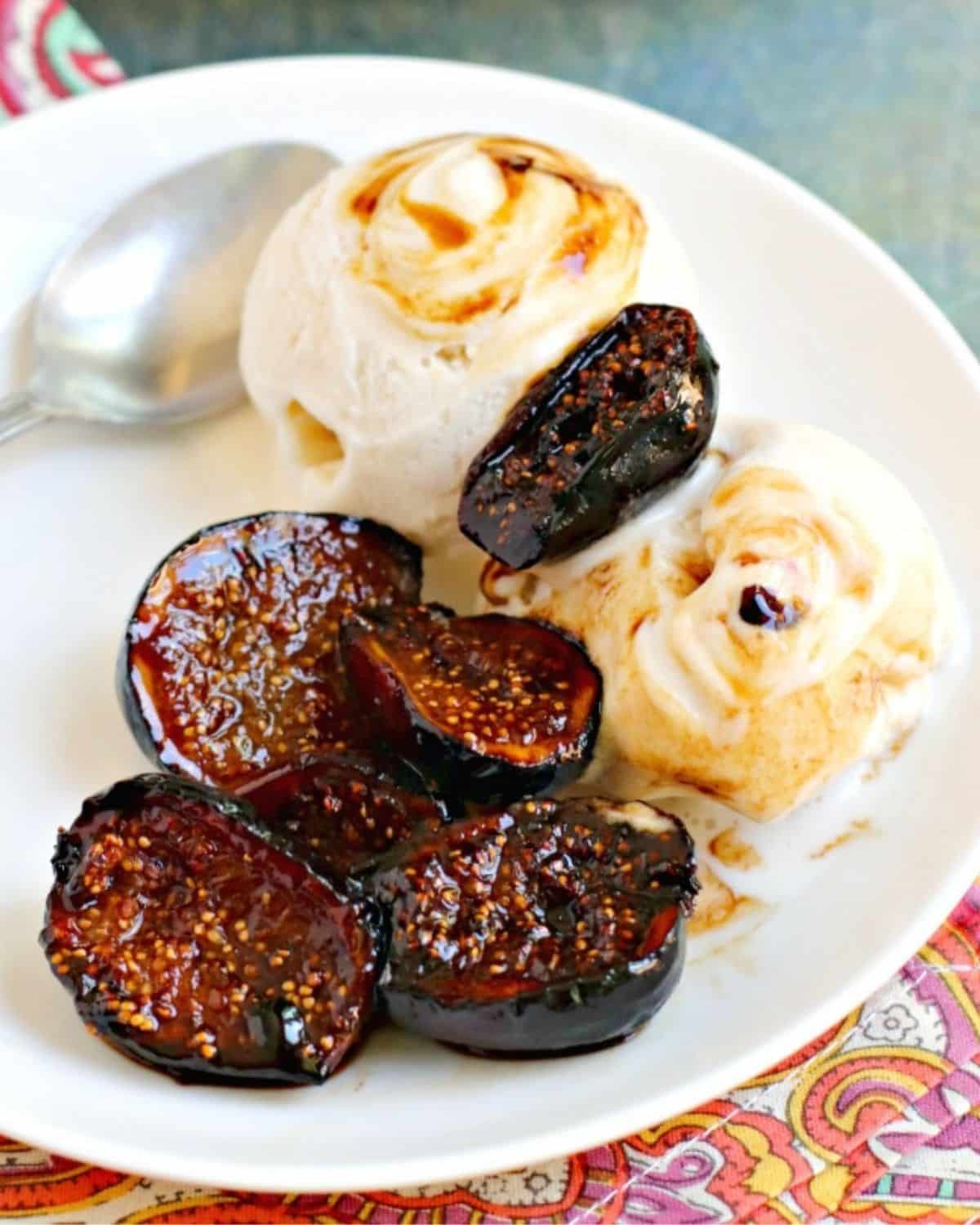 Scoops of vanilla ice cream on a plate topped with figs