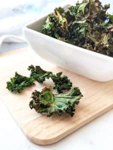 Seasoned air fried kale chips in a bowl.