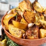 Bowl of roasted potatoes garnished with lemon