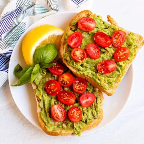 Plate with avocado toast and lemon wedge
