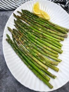 Platter of asparagus with lemon wedge