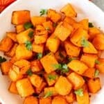 Bowl of butternut squash cubes with text overlay: Air Fryer Butternut Squash.