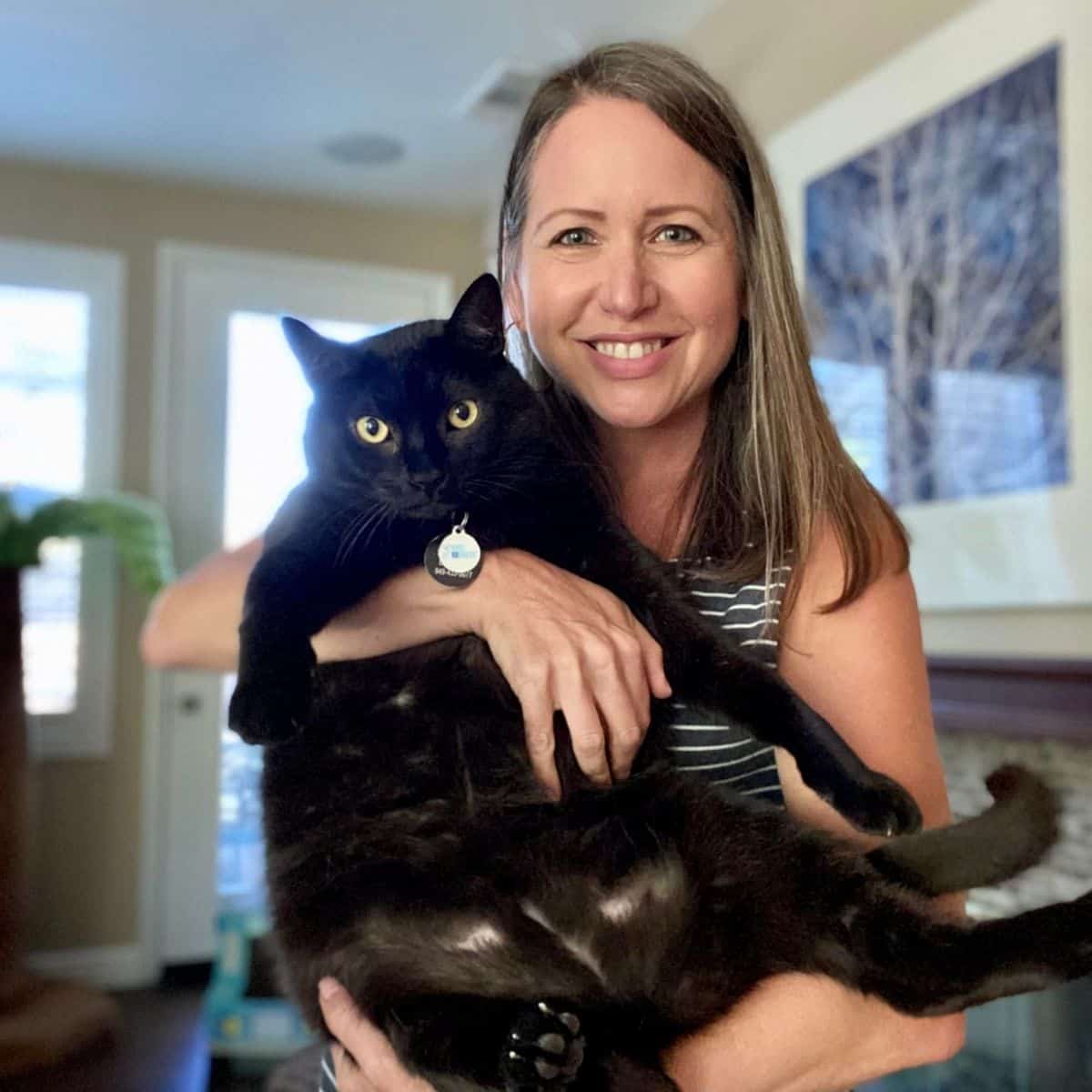 Amy holding her black cat Ozzy.