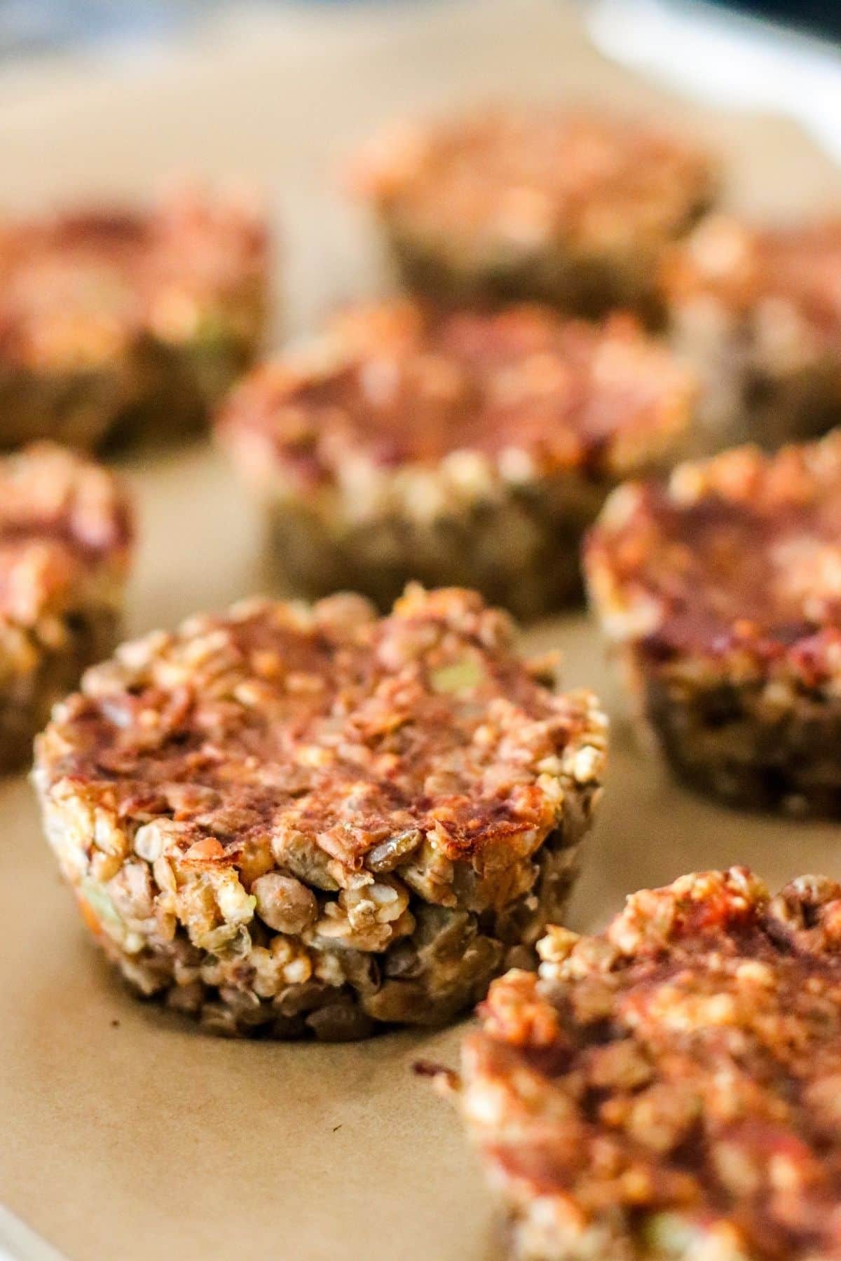 Mini meatloaves of parchment paper after they have been removed from the pan.