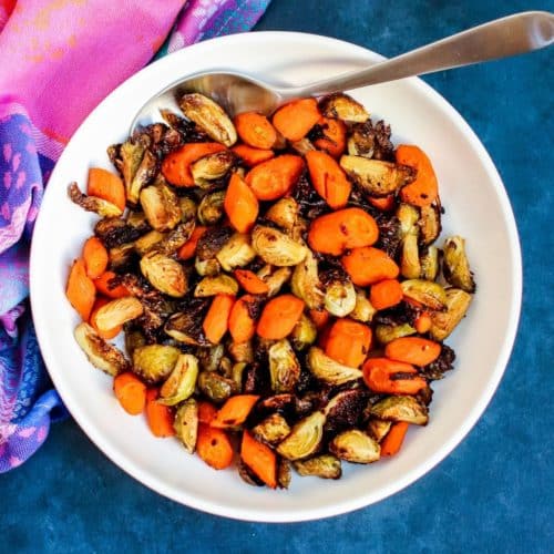 Bowl of roasted vegetables with serving spoon in it.