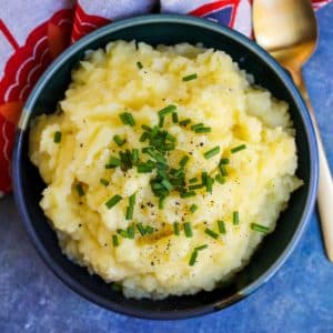 Bowl of mashed potatoes topped with fresh chives.