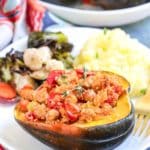 Dinner plate with stuffed acorn squash, roasted vegetables, and mashed potatoes.