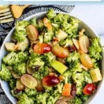 Bowl of broccoli salad with grapes, apples, dried cranberries, and walnuts tossed in a Dijon mustard vinaigrette, with text overlay: Broccoli Grape Salad *No Mayo!).