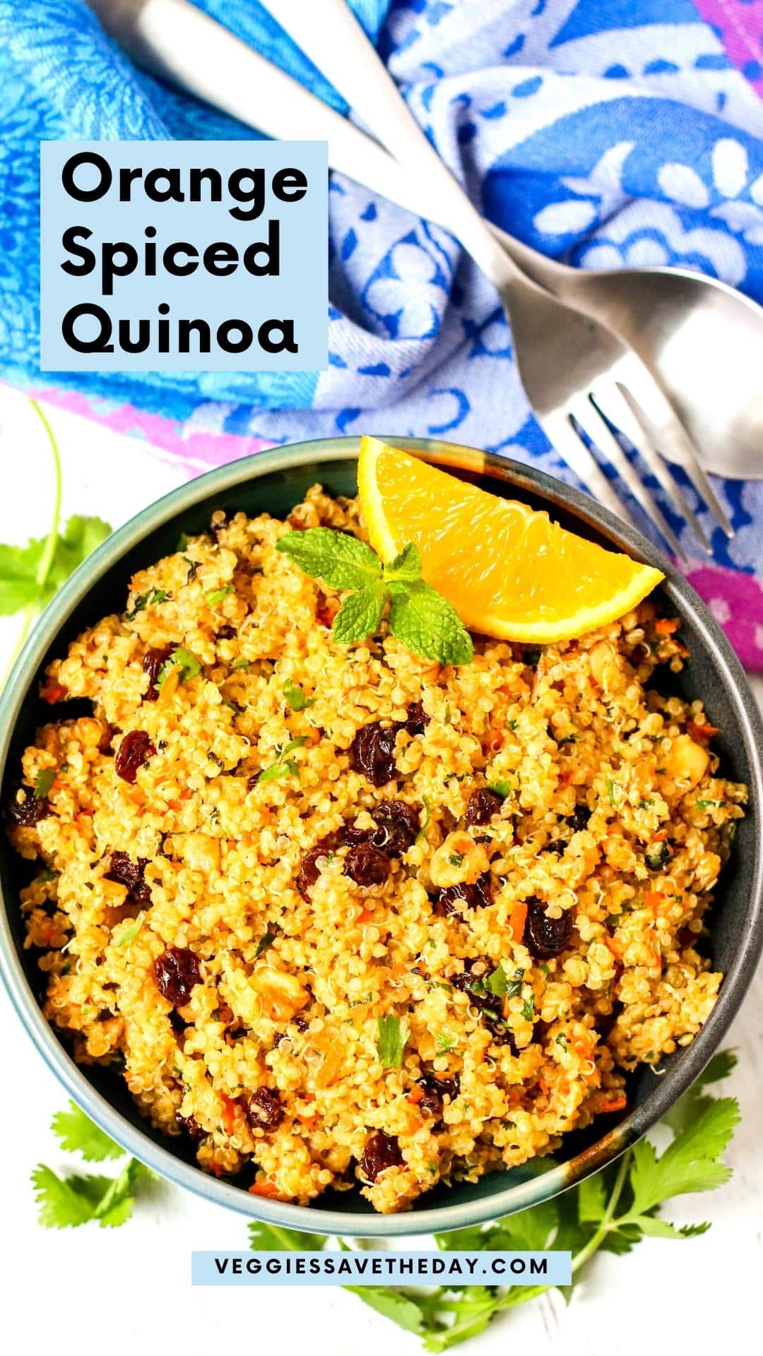 Bowl of spiced quinoa garnished with orange wedge and sprig of fresh mint.