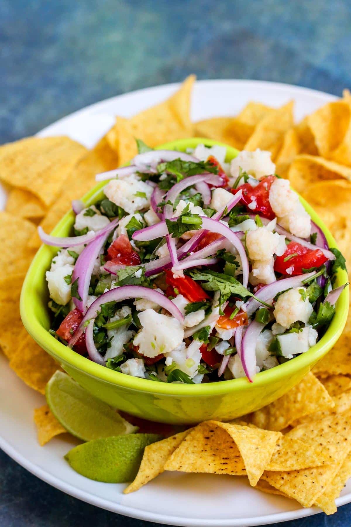 Plate of tortilla chips with bowl of cauliflower ceviche in the middle.