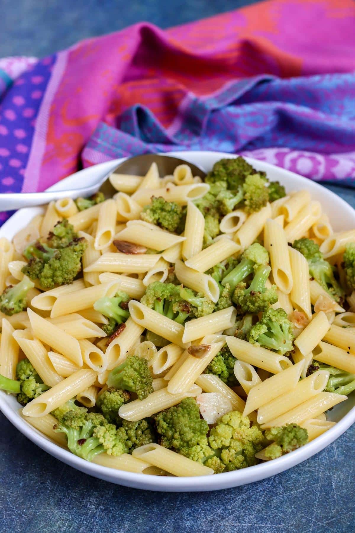 Side view of serving bowl of penne and roasted Romanesco ready to eat.