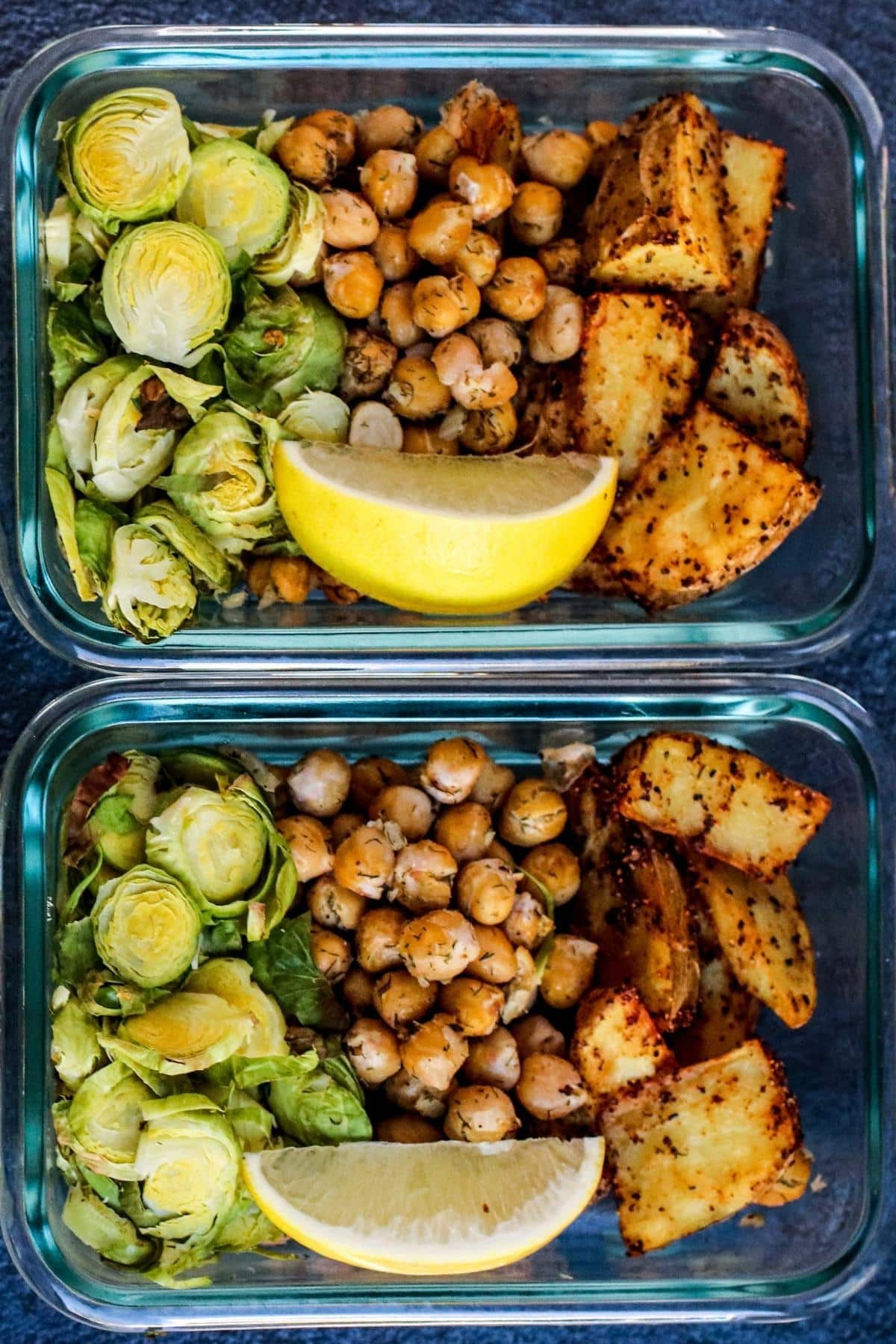 Roasted Brussels sprouts, chickpeas, lemon wedges, and potatoes in glass storage containers.