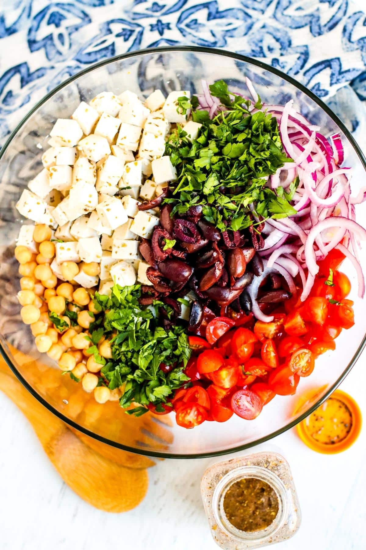 Salad ingredients in a mixing bowl and dressing ingredients in a jar.