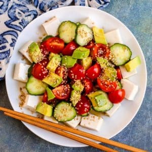 Plate of tofu salad with wooden chopsticks.